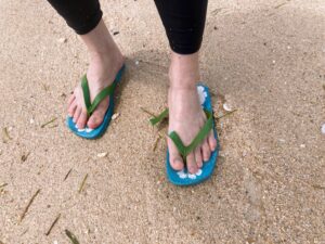 ビーチサンダルとサンゴの砂浜